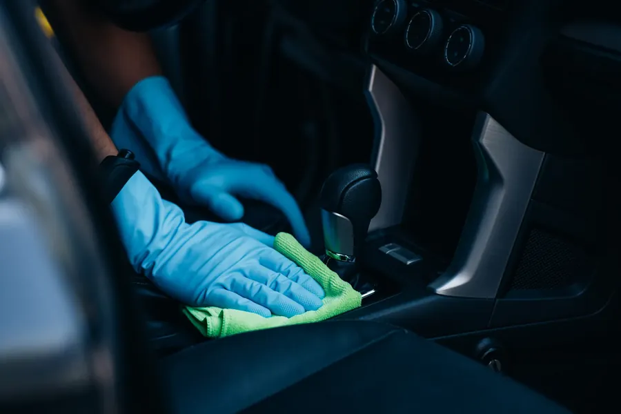Higienização interna automotiva sendo feita no console de um veículo em Bauru