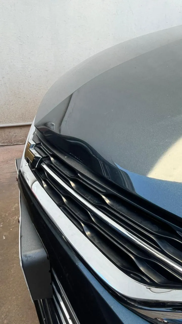 Amassado no capô de carro cinza antes do reparo com martelinho de ouro
