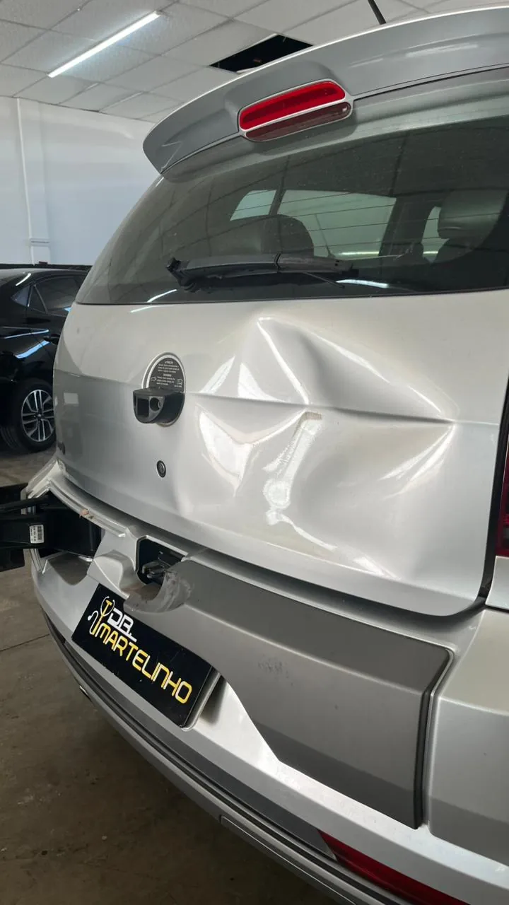 Amassado na tampa traseira de carro prata antes do reparo sem pintura