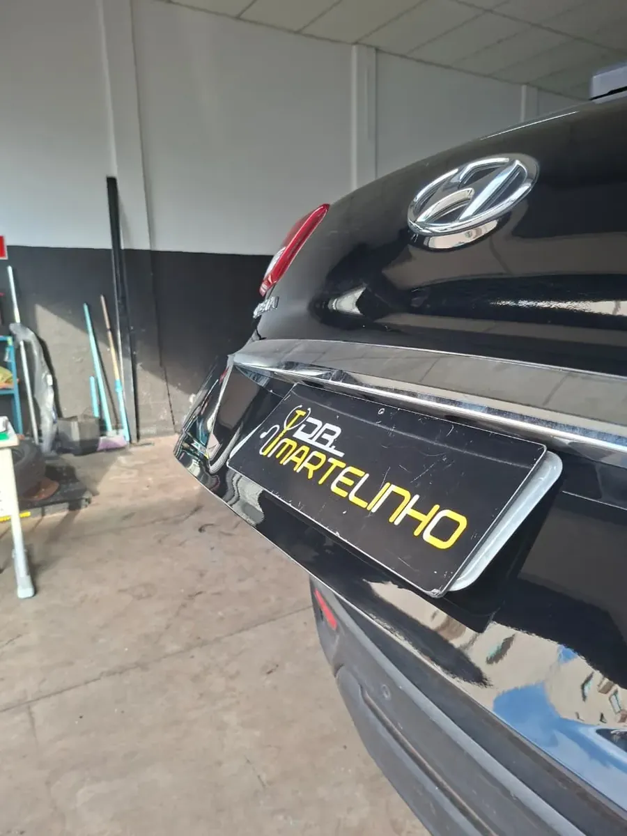 Reparo de amassado na tampa do porta-malas de carro preto na oficina em Bauru